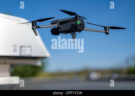 Drone being used to perform an aerial inspecting of HVAC RTU equipment on a commercial roof. Stock Photo