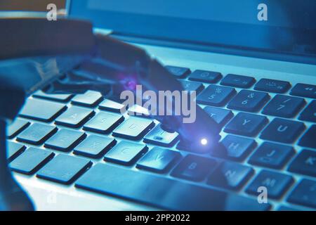 Robotic hand typing on a keyboard . Concept of future and AI. Stock Photo