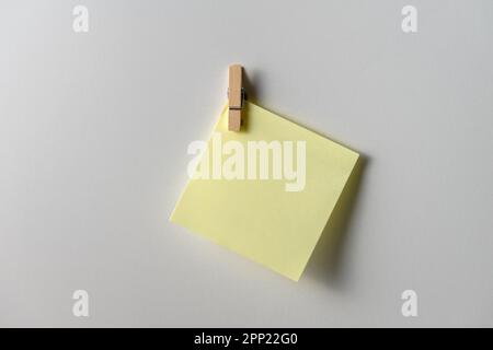 Yellow note paper on white background. Copy space. Close up. Stock Photo