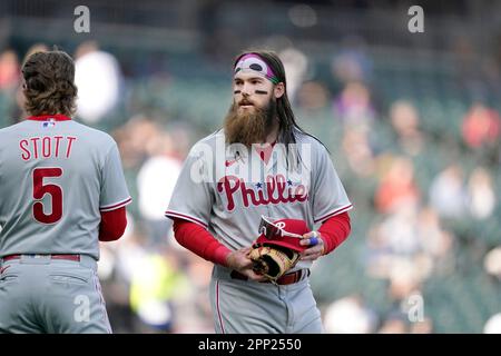 Philadelphia Phillies - Brandon Marsh looking excited, while holding the  end of a baseball bat in his right hand. He is wearing batting gloves, a  long sleeve red shirt, a red hat