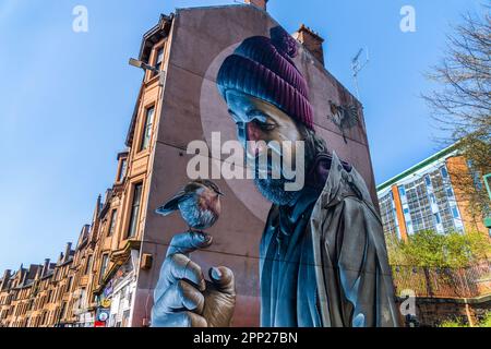 Mural painted on the gable wall of a block of Glasgow tenement houses indicating a man holding a robin on his fingers, High Street, Glasgow, Scotland, Stock Photo