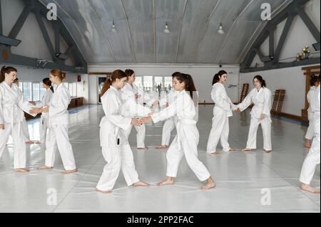 Teenage girls practicing new moves during aikido class Stock Photo