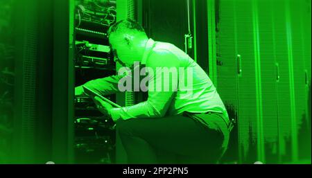 Composition of interference over caucasian businessman using tablet in server room Stock Photo