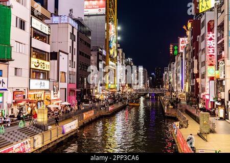 Osaka Japan April 2023, Dotonbori River canal at night time with neon lights and crowds gathering for dinner and entertainment, street scene,Japan Stock Photo