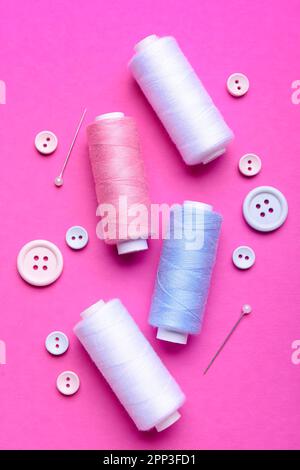 Composition with thread spools, buttons and ball pins on color background Stock Photo