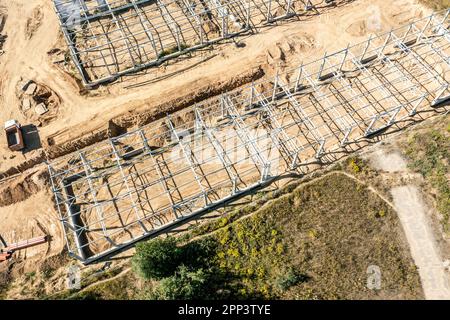 construction of new warehouse building or factory in suburb area. metal frame construction. drone photo. Stock Photo