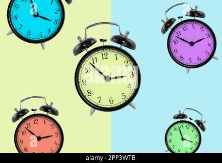 Clocks with different colors isolated on green and blue background Stock Photo