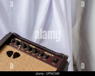 Small acoustic guitar amplifier with pick guitar on amplifier mask, isolated on white background Stock Photo