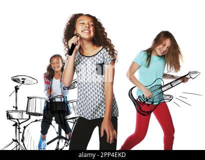 Caught up in the music. Studio shot of children playing rock music on imaginary instruments. Stock Photo
