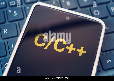 C Programming language for mobile development, concept. Smartphone on the laptop keyboard, the programmer workplace. inscription on the mobile phone s Stock Photo