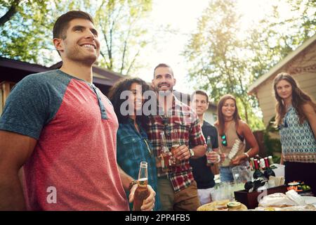 Barbecue blowout. a group of friends having lunch in their backyard. Stock Photo