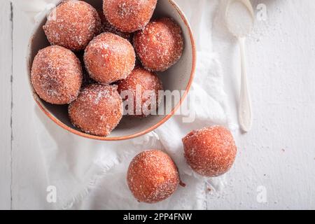 Homemade mini doughnuts as a tasty snack. Doughnuts served with milk and sugar. Stock Photo