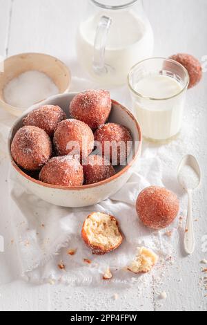 Homemade mini doughnuts with caster sugar and milk. Doughnuts served with milk and sugar. Stock Photo