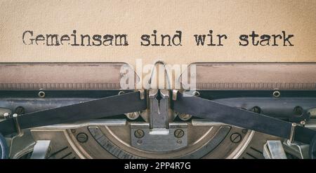 Text written with a vintage typewriter - Together we are strong in german - Gemeinsam sind wir stark Stock Photo