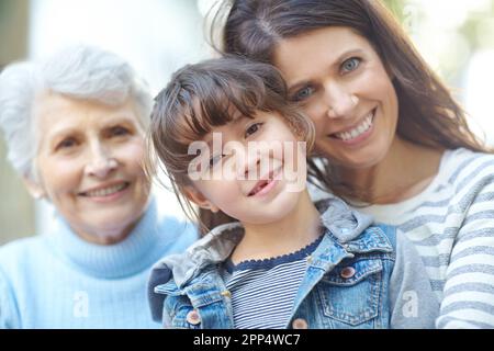 Family over everything. Portrait of a three generational family sitting outdoors. Stock Photo