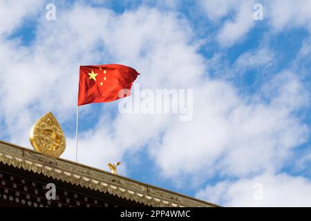 Peoples Republic of China Flag  flutters in the wind on the Nanwu tibetan temple. Stock Photo