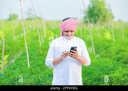 Young indian farmer showing Smart phone , Farmer talking on phone in ...