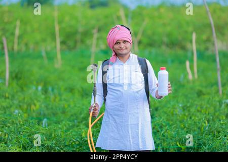 Young indian farmer showing Smart phone , Farmer talking on phone in farm, happy indian farmer Stock Photo