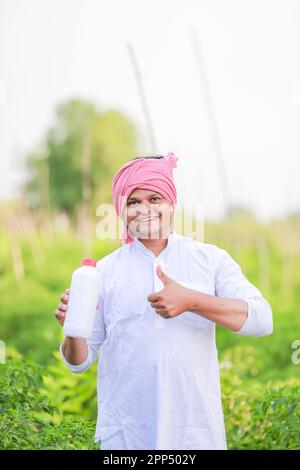 Young indian farmer showing Smart phone , Farmer talking on phone in farm, happy indian farmer Stock Photo