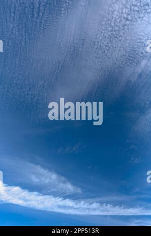Contrails and cloud formations in the blue sky, Bavaria, Germany Stock Photo