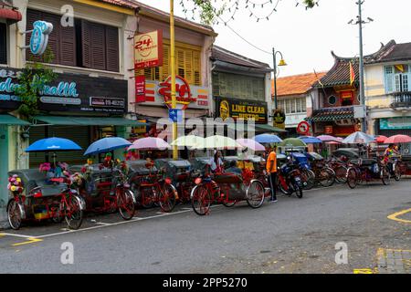 Colorful cycle rickshaws parking by Jalan Masjid Kapitan Kelingin. George Town, Penang Island, Malaysia, Southeast Asia. Stock Photo