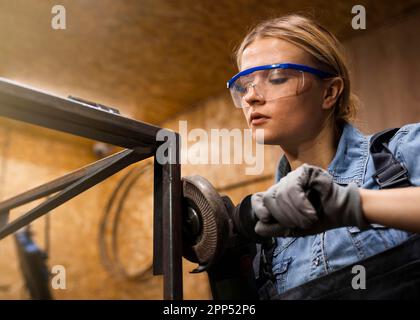 Female welder using angle grinder Stock Photo