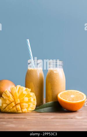 Front view smoothie bottles with mango orange Stock Photo