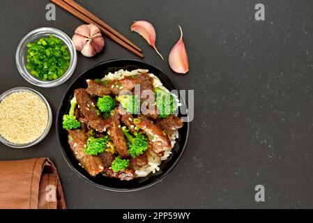 Beef stir-fry with broccoli on black background with copy space. Top view, flat lay Stock Photo