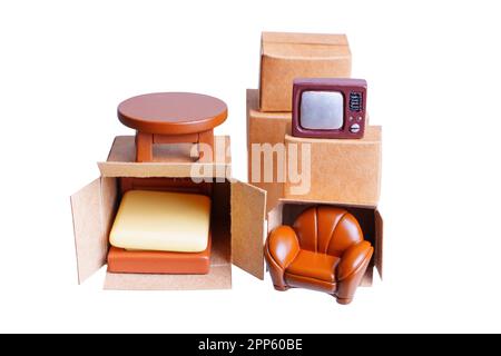 Set of tiny moving boxes with various tiny furniture figurines unpacked, isolated on a white background. Home decor, interior design, moving and stora Stock Photo