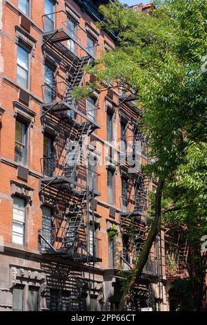 An old red brick apartment building with fire escape stairs. New York City, USA - August 20, 2022. Stock Photo