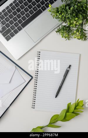 Modern white office desk table with laptop, notebook and other supplies. Top view, flat lay. Stock Photo