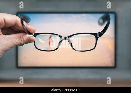 Classic glasses in front of TV screen. Glasses for viewing a stereo image. Protective glasses from negative impact of the monitor while working on the Stock Photo
