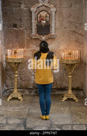 Jerusalem, Israel - November 12th, 2022:A woman praying in the church of Saint Alexander Nevsky, the old city of Jerusalem, Israel. Stock Photo