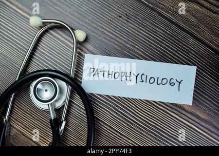 Concept of Pathophysiology write on sticky notes with sthethoscope isolated on Wooden Table. Stock Photo