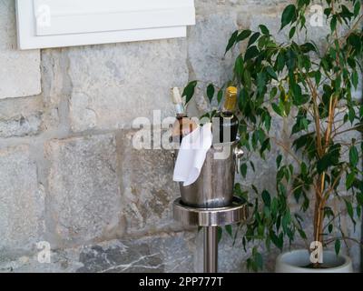 Wine bottle in bucket with ice on outdoors banquet Stock Photo