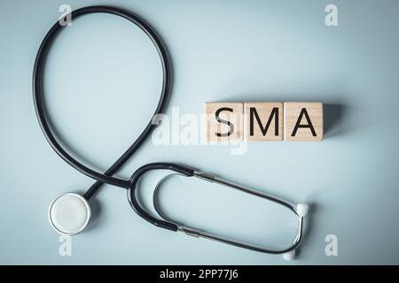 SMA, spinal muscular atrophy, Written on wooden blocks, a rare disease in which, due to a genetic defect, neurons in the spinal cord responsible for m Stock Photo