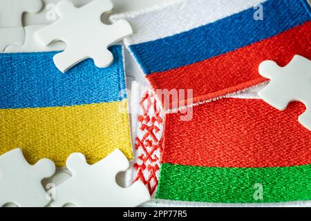 The flag of Belarus and the background of the flags of Russia and Ukraine among the jigsaw puzzles, the concept of the political situation, the role o Stock Photo