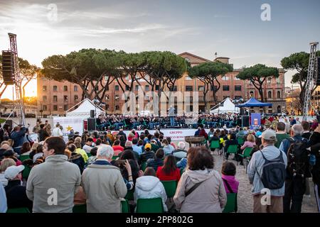 Spectators attend the concert of the Italian army band conducted by Sergeant Major Pasquale Casertano. Figures from all over the world united by their passion for the world of ancient Rome have set up an ancient village at the Circus Maximus to celebrate the 2776th anniversary of the foundation of Rome. The event organized by the Gruppo Storico Romano, a non-profit cultural association born in 1994 from a passion for ancient Rome, this year sees the participation of 2500 re-enactors belonging to 80 associations from 16 nations. The largest number of re-enactors come from Spain. The day ends wi Stock Photo