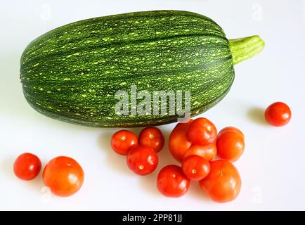 Vegetable marrow zucchini and cherry tomatoes isolated on white background. Photography of one fresh squash, top view. Theme of zucchini, organic food Stock Photo