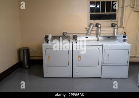 Denver, Colorado, United States - 4.21.2023: old apartment building laundry room machines Stock Photo