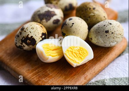 boiled eggs food, quail eggs on wooden plate, breakfast eggs with fresh quail eggs on table background Stock Photo