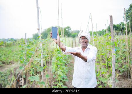 Indian happy farmer holding mobile in hand Stock Photo