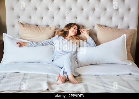Whats the rush, its the weekend. a beautiful young woman waking up in bed feeling refreshed. Stock Photo