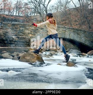 Making her way across frozen lakes. Full length shot of an attractive young woman spending the day outside during winter. Stock Photo