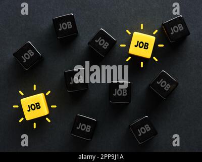 To search and find a job. Vacancy options in the labor market. Employment, hiring and recruiting. The word job on black and yellow cubes. Stock Photo