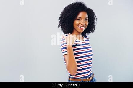 Ive got something to share with you. Studio shot of an attractive young woman pointing at copy space against a grey background. Stock Photo