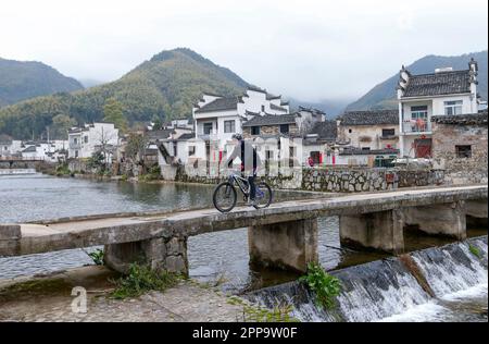 (230423) -- BEIJING, April 23, 2023 (Xinhua) -- Arming Schober rides past a stone bridge in Yixian County, east China's Anhui Province, March 23, 2023. Arming Schober, a German owner of a homestay in Tachuan Village of Yixian County, participated in the 18th China Huangshan (Yixian) International Cycling Open. Yixian County, one of the six counties of ancient Huizhou, is located at the southern foot of Huangshan Mountain. The China Huangshan (Yixian) International Cycling Open is held here for 18 consecutive years, as brand events achieving high-quality integration of sports and tourism. This Stock Photo