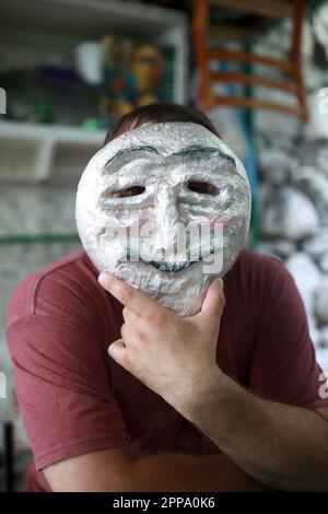 Portrait of man in anonymous mask in backyard Stock Photo