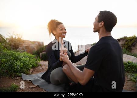 Happy millennial african american lady and man in sportswear practice yoga, enjoy calm, relax Stock Photo