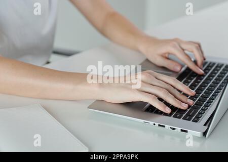 Hands of young woman coding on laptop at minimalistic desk Stock Photo